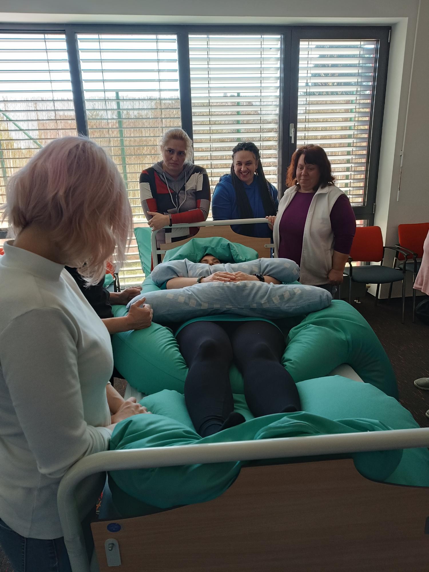 Zdravotníci v roli pacientů při polohování na lůžku